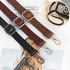Close-up view of brown and black PU leather crossbody bag straps with gold hardware.