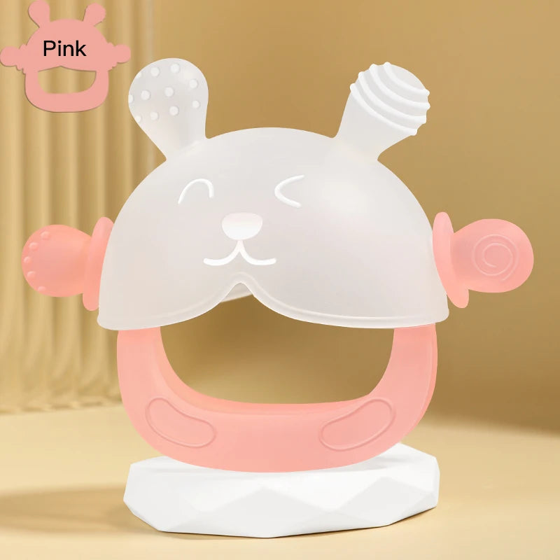 A pink silicone teether shaped like a cute bunny for babies, displayed on a white stand.