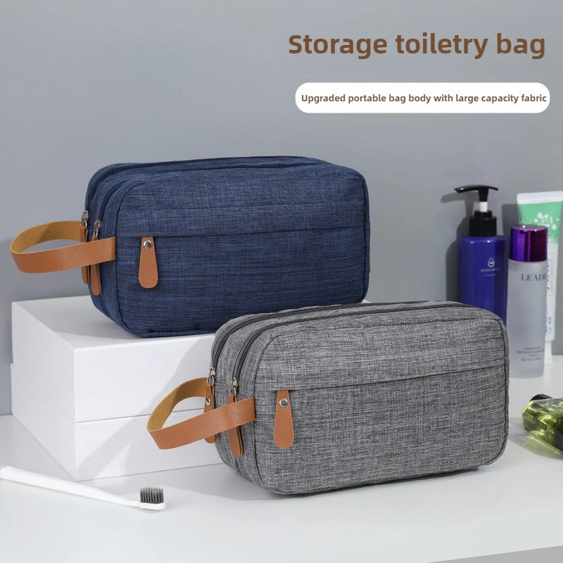 A dark blue and gray storage toiletry bag with leather straps is displayed on a white surface.