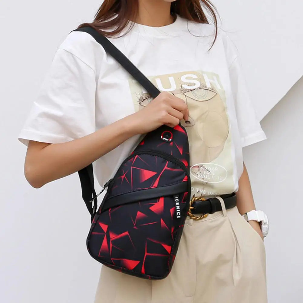 A woman is holding a black and red geometric patterned waterproof crossbody chest bag against a white t-shirt and beige pants