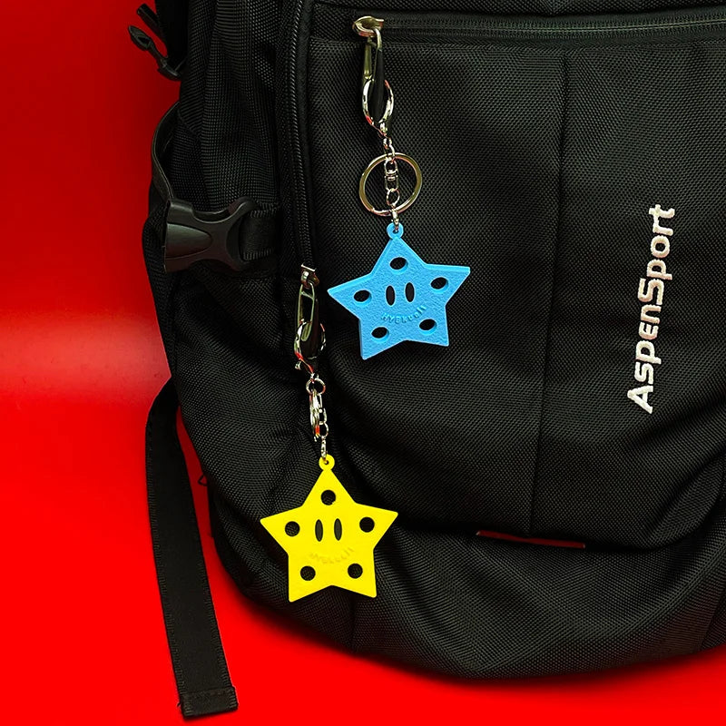 Un sac noir présente deux porte-clés en silicone pour chaussures, un bleu et un jaune, suspendus à une pince.