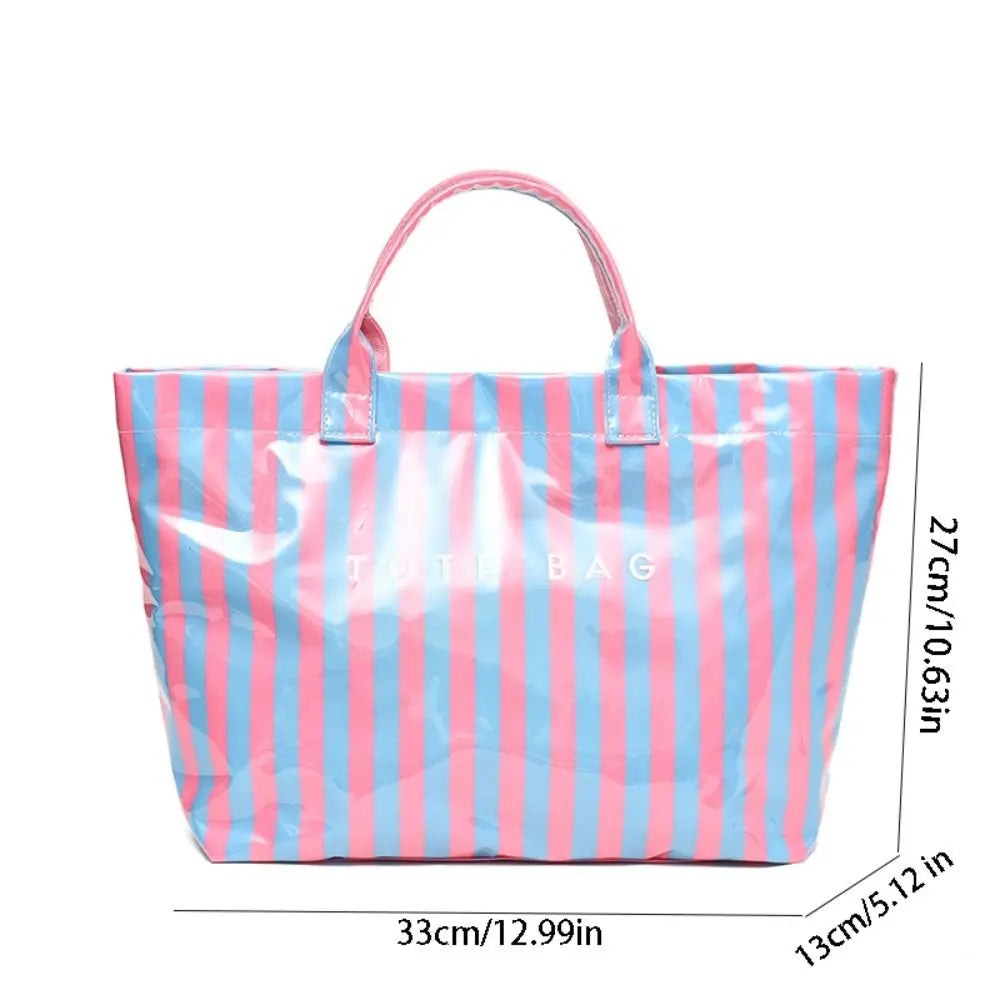 A pink and blue striped transparent PVC tote bag shown flat.