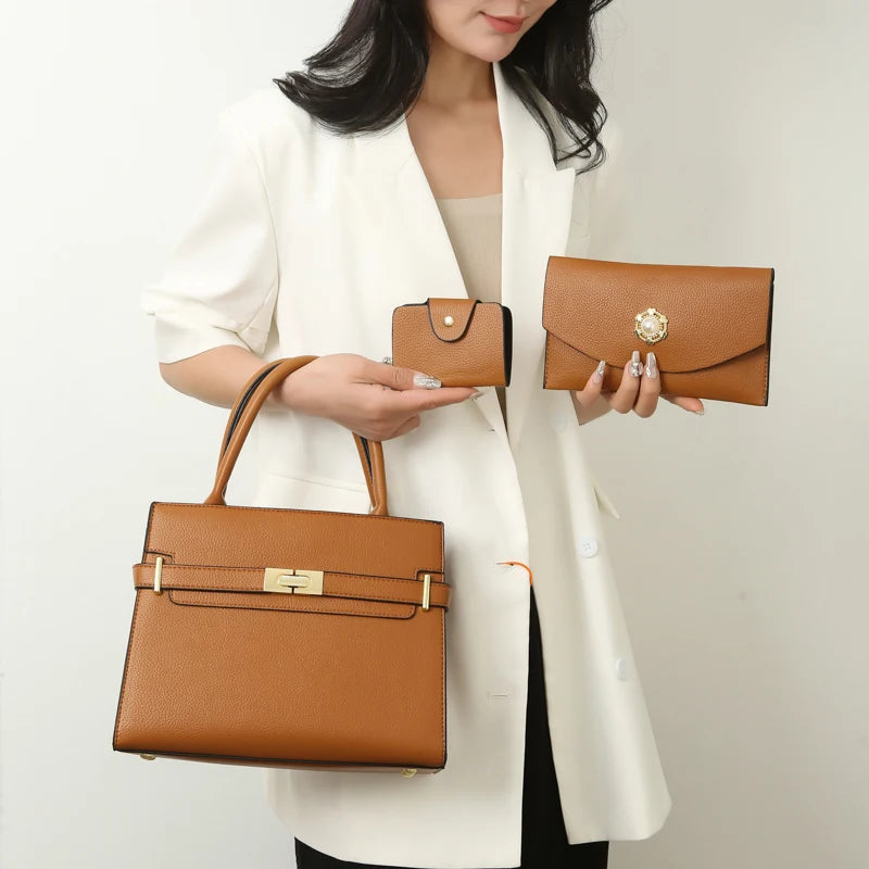 A woman holds a tan leather handbag and a matching wallet in front of a white blazer.