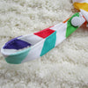 A colorful reusable waterproof snack bag with a zipper closure lying on a white fluffy surface.