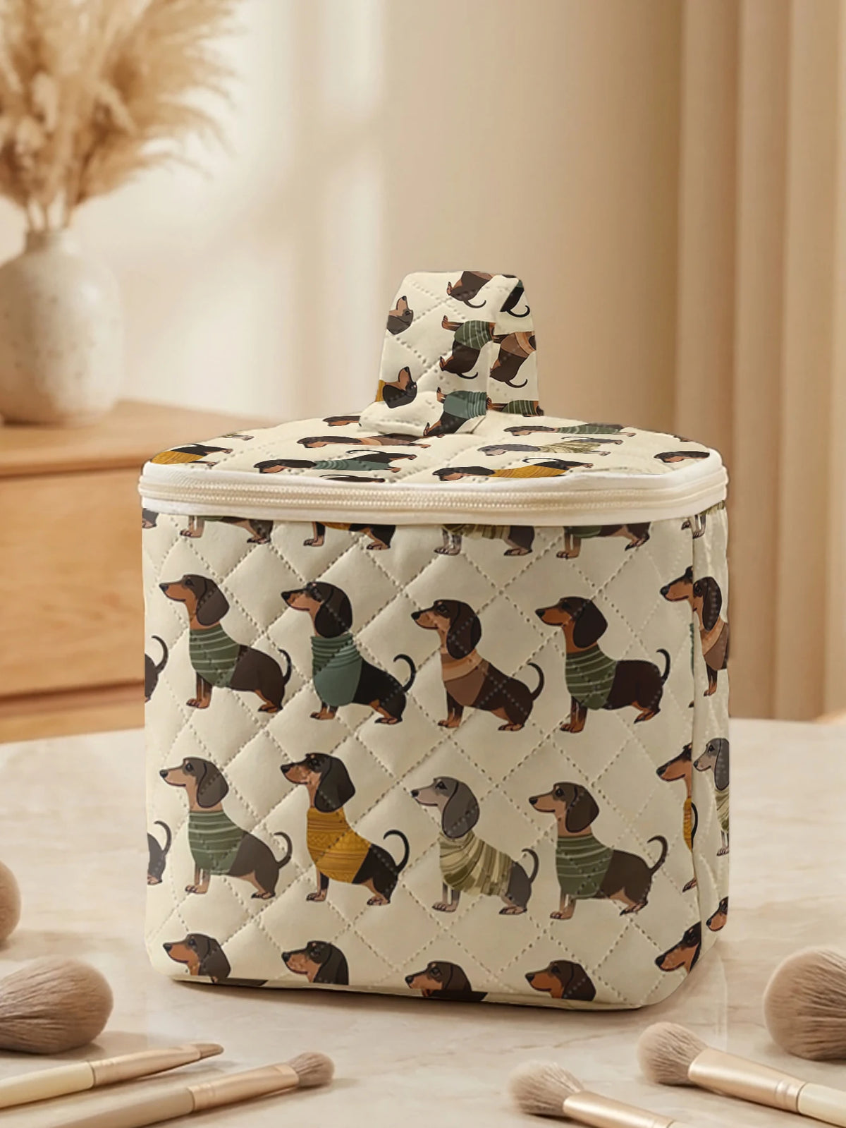 A quilted cosmetic travel bag featuring a repeating pattern of dachshunds in earthy tones.