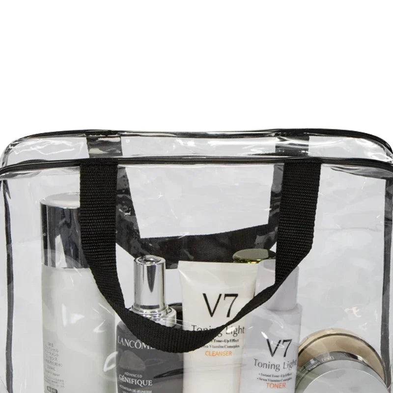 A clear PVC travel toiletry bag with a black strap, containing three skincare products.