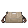 A beige luxury cowhide shoulder bag with stitching and a leather tag is shown from the front.