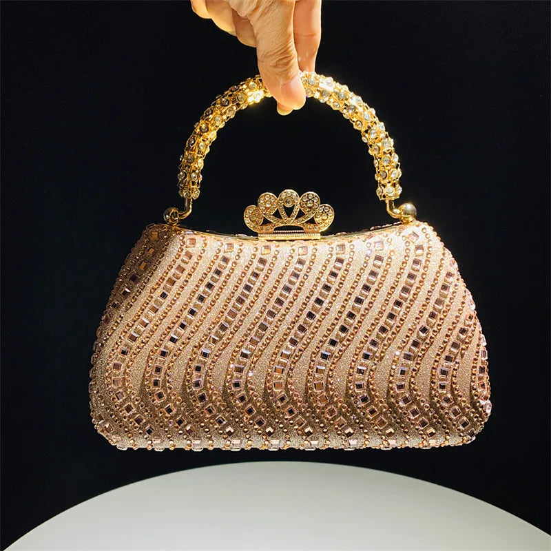 A close-up of a gold crystal-embellished evening clutch bag with a chain strap against a dark background.