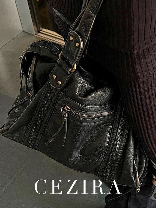 A black vintage PU leather tote bag with quilted texture and zipper pockets is shown against a dark background.