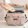 A pink insulated thermal lunch bag is shown open, containing sliced food, being held by a person.