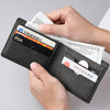 A hand is opening a black PU leather wallet to show various credit cards and banknotes.