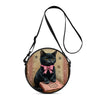 A black cartoon cat illustration on a round crossbody bag with a pink bow and an open book design.