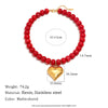 A necklace featuring red resin beads and a gold heart charm, measuring 41+5cm.