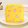 A yellow portable pouch with a repeating pattern of pink and white ice cream cones is displayed on a white plate.