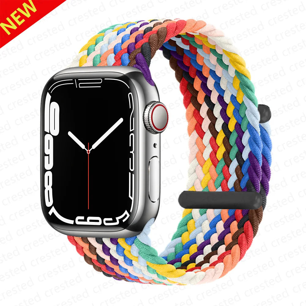 A black Apple Watch is shown attached to a colorful braided stretch band for the watch.