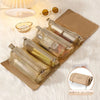 A set of portable detachable makeup bags in gold and beige leather resting on a white fluffy surface.