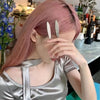 A woman with pink hair is touching her eyes while wearing a silver metal star hairpin set.