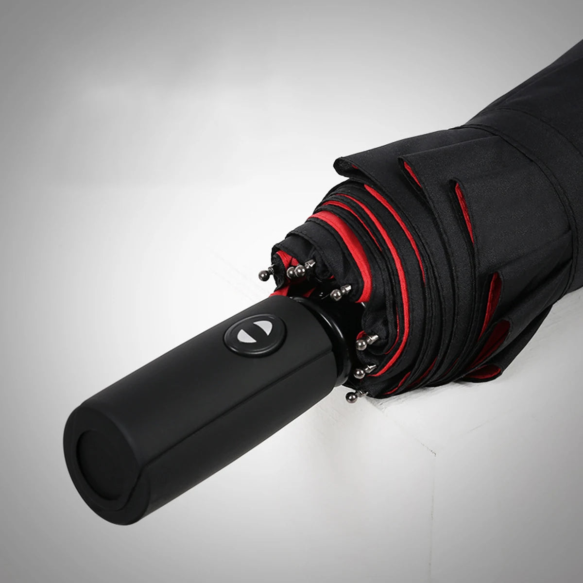 Close-up of a black heavy-duty windproof automatic umbrella handle with red accents.
