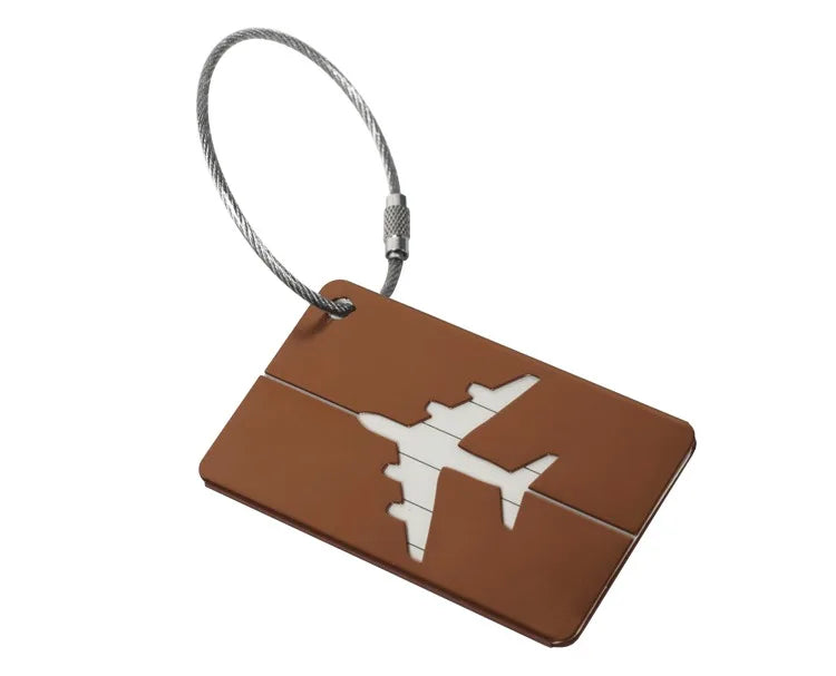 A brown aluminum luggage tag with a silver cord attached.
