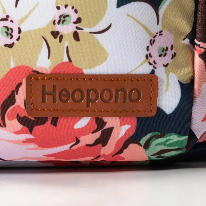 Primer plano de una bolsa de almuerzo con tela estampada, diseños florales en rosa, verde y crema.