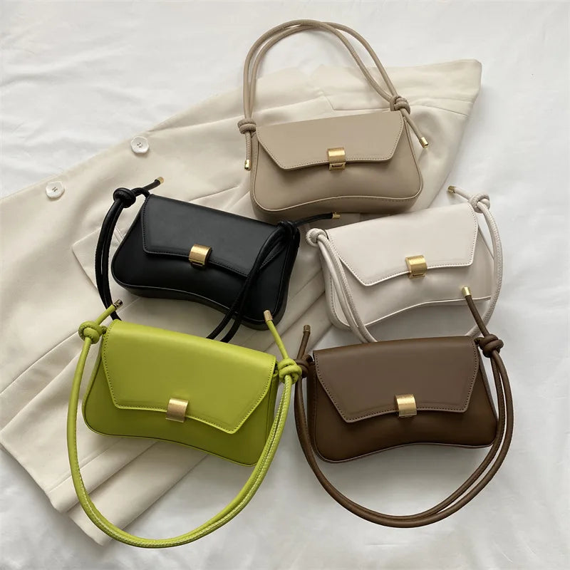 A collection of five solid color leather crossbody bags in beige, black, olive green, cream, and brown displayed on a white s