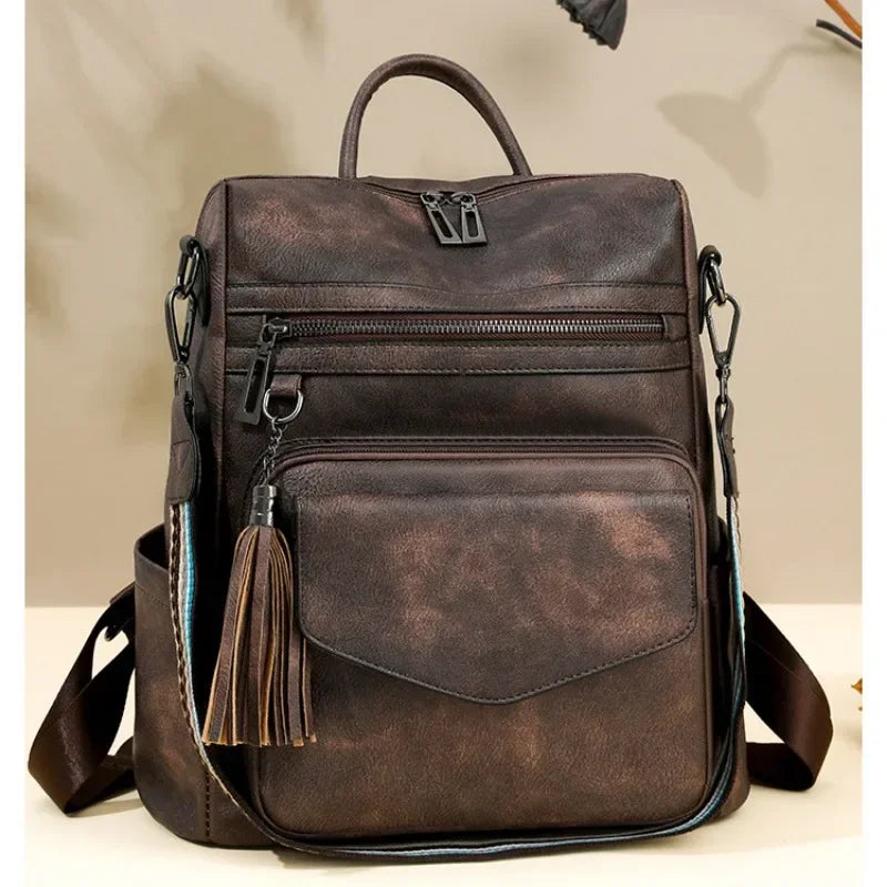 A dark brown retro PU leather travel backpack with a leather strap and tassel detail.