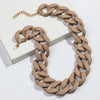 A necklace featuring a matte beige chain and gold accents displayed on a white box.