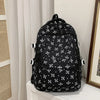 Mochila negra con estampado floral y múltiples bolsillos exhibida en un estante blanco.