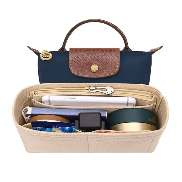 A navy blue felt organizer insert for handbags with a brown leather strap and various accessories inside.