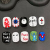 A set of press-on nails featuring various cartoon and text designs on a dark gray surface.