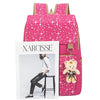 A pink star-patterned backpack featuring a white frame with the name Narcisse and a teddy bear charm.