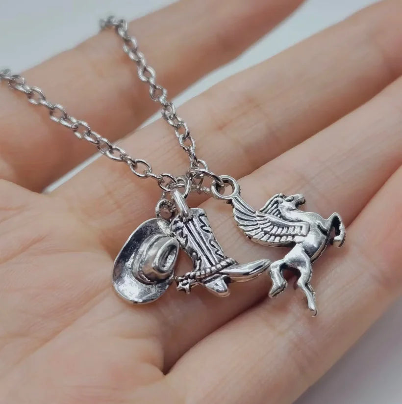 Silver necklace featuring a Western cowboy boot, hat, and horseshoe charm.