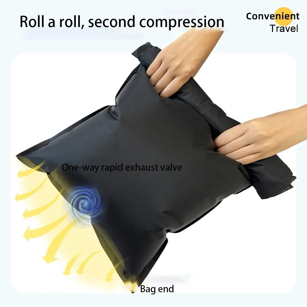 Hands are compressing a black reusable vacuum storage bag, demonstrating the one-way rapid exhaust valve.