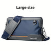 A large gray and blue crossbody bag with a padded strap and silver hardware.
