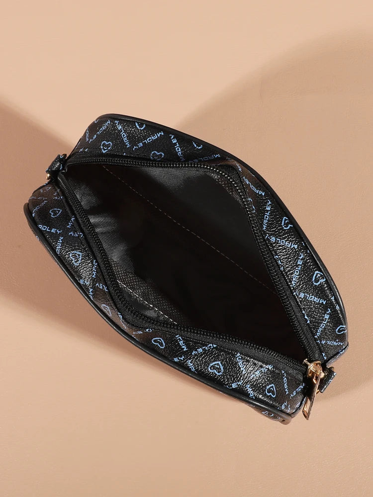 A black fashion crossbody shoulder bag with a patterned fabric and gold hardware shown from above.