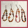 A display of five beaded phone charm straps with anti-lost lanyards featuring various colored stones and beads.