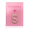 A pink leather passport holder with a gold embossed letter S and a pink airplane symbol.
