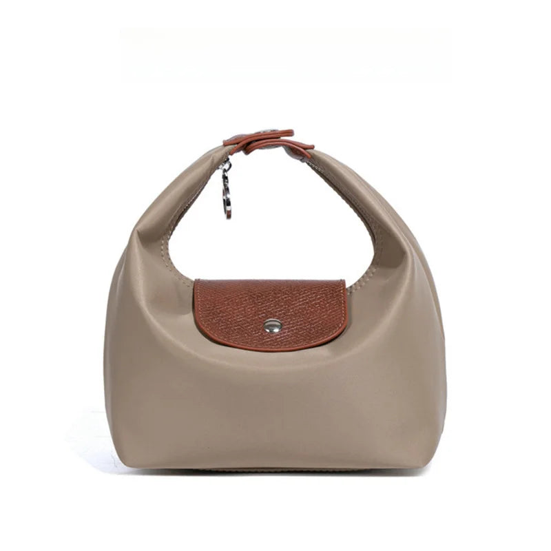 A beige nylon dumpling crossbody shoulder bag with a brown leather strap and flap.