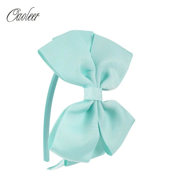 A light mint green striped bow headband product.