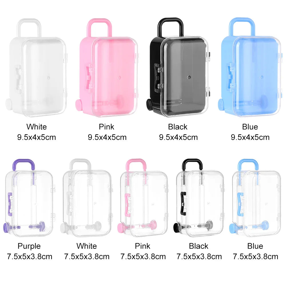 A collection of miniature doll suitcases in various colors including white, pink, black, blue, and purple.