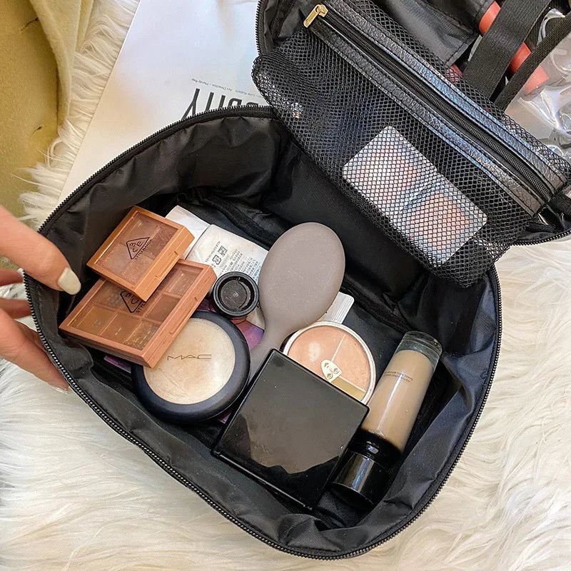 A black makeup storage pouch is open, revealing various cosmetic products and a separate mesh pocket.