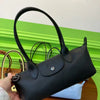 A black storage shoulder bag is shown against a bright green wall, held by a hand.