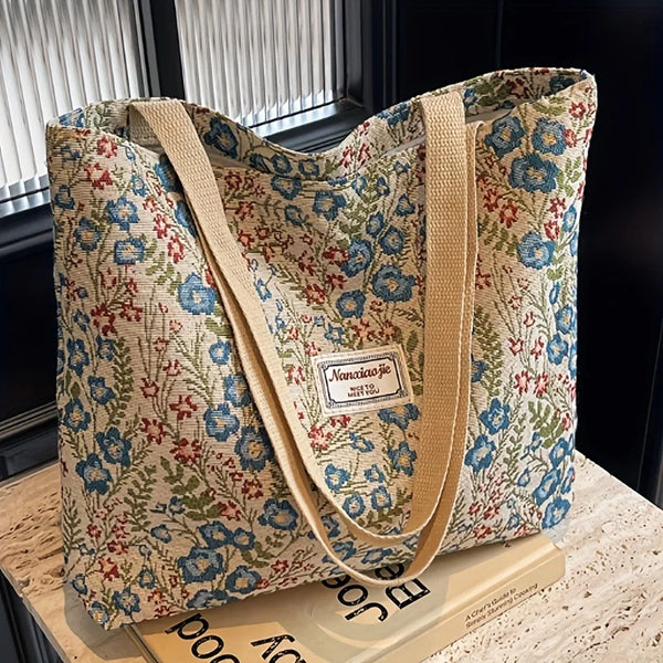 A beige and blue floral bohemian corduroy tote bag resting on a light surface.