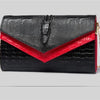 Black alligator pattern leather clutch bag with red accents and gold chain detail