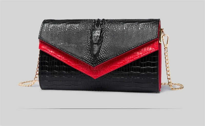 Black alligator pattern leather clutch bag with red accents and gold chain detail