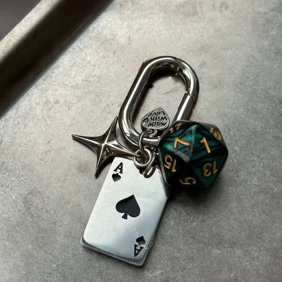 Silver keychain featuring a die shaped charm and an Ace of Spades pendant