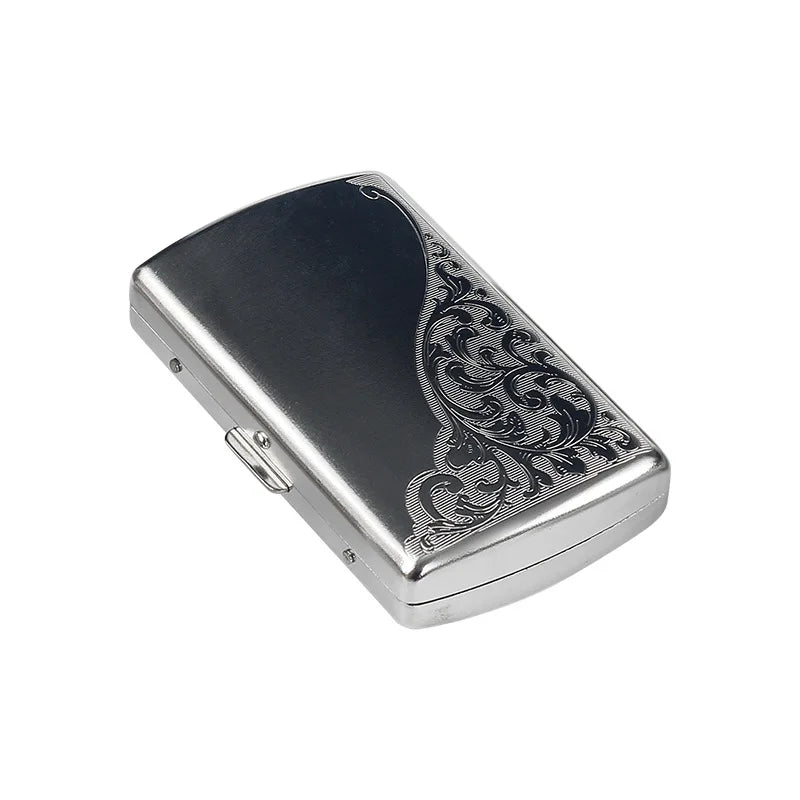 A silver metal cigarette case with an ornate scroll design, shown from a slight angle.