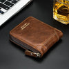 A brown retro PU leather men's wallet with a silver zipper resting on a dark surface next to a laptop and a glass of amber li