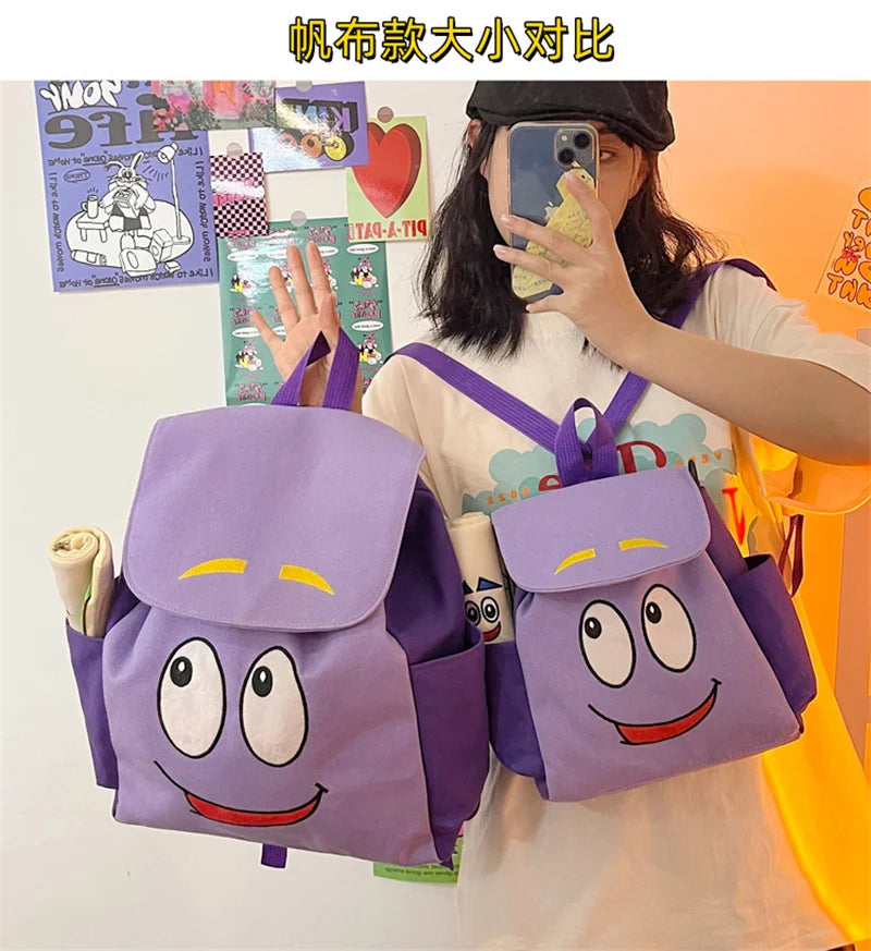 A person is holding a purple Dora The Explorer cartoon flannel backpack and a smartphone.
