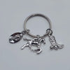 Silver keychain set featuring a cowboy boot, hat, and horseshoe charms.